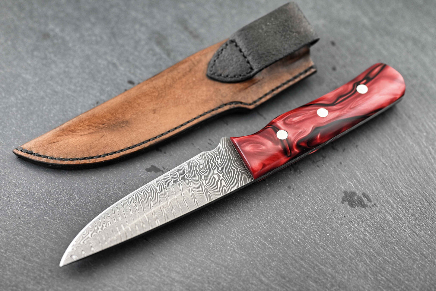 Jagdmesser mit Kirinite-Griff und Damastklinge, rot in Lederscheide