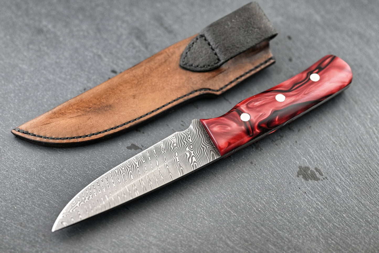 Jagdmesser mit Kirinite-Griff und Damastklinge, rot in Lederscheide