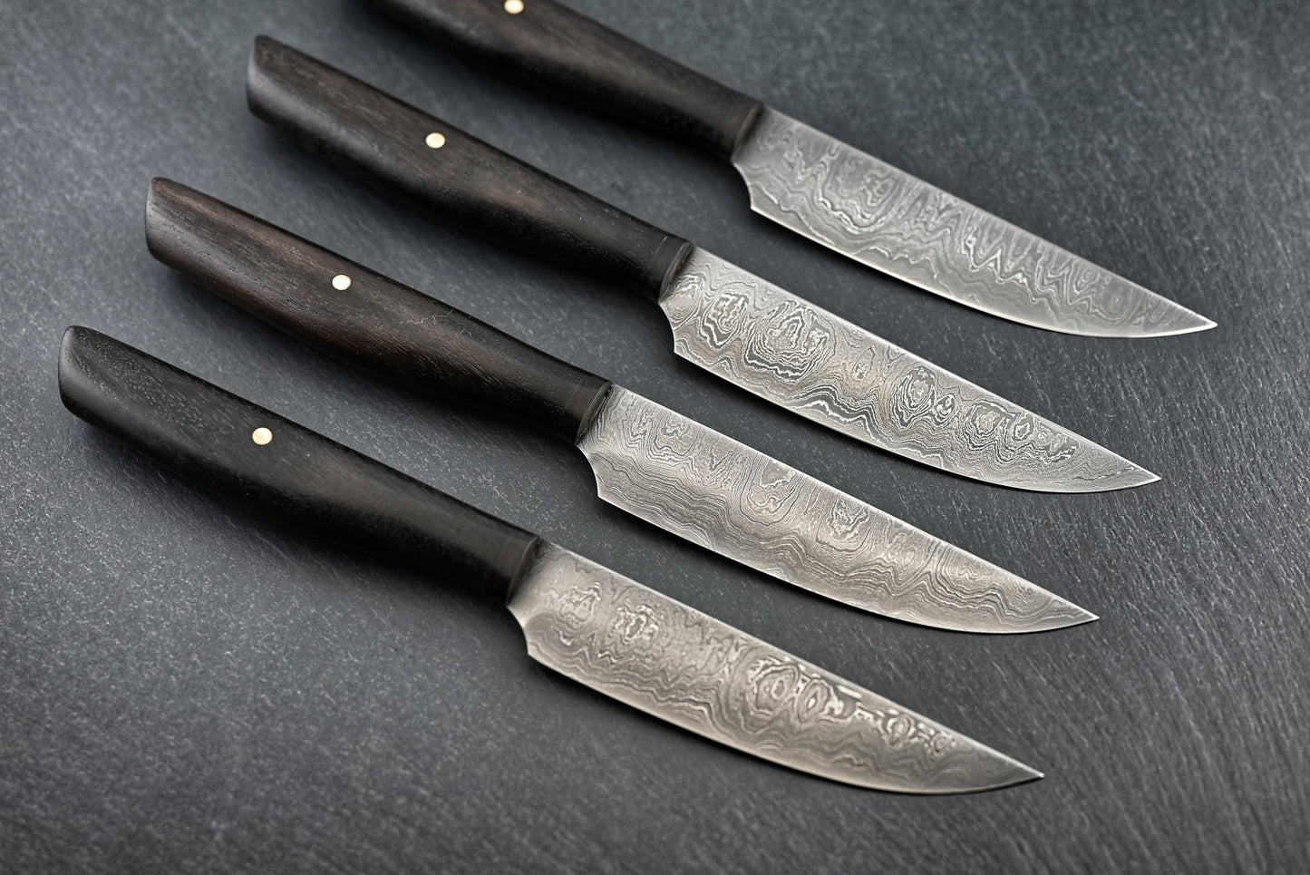 4 Damast-Steakmesser mit schmalen Klingen und dunklen Holzgriffen, spitze Messerform