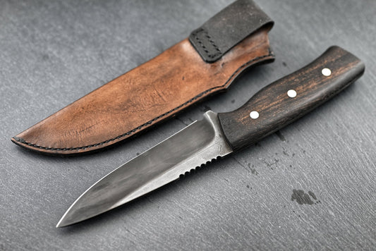 Jagdmesser „RoughRider“ mit gezahnter Klingenrückseite und brauner Scheide mit Lasche