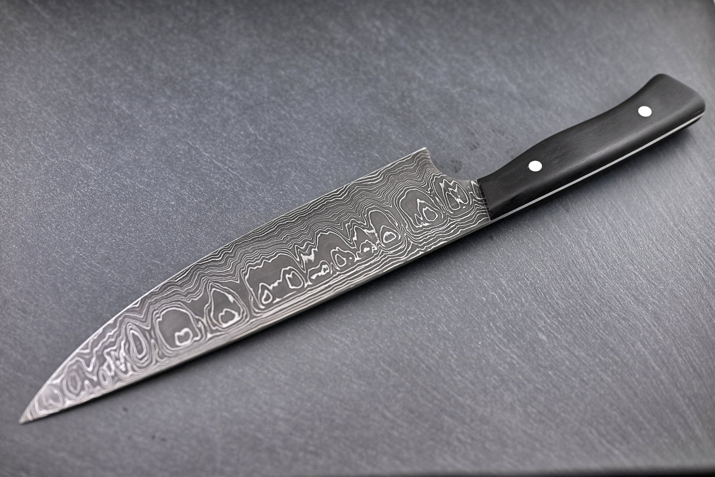 Damast-Chefmesser 22 cm Seitenansicht: Wilddamastklinge, schwarzer Griff mit Nieten