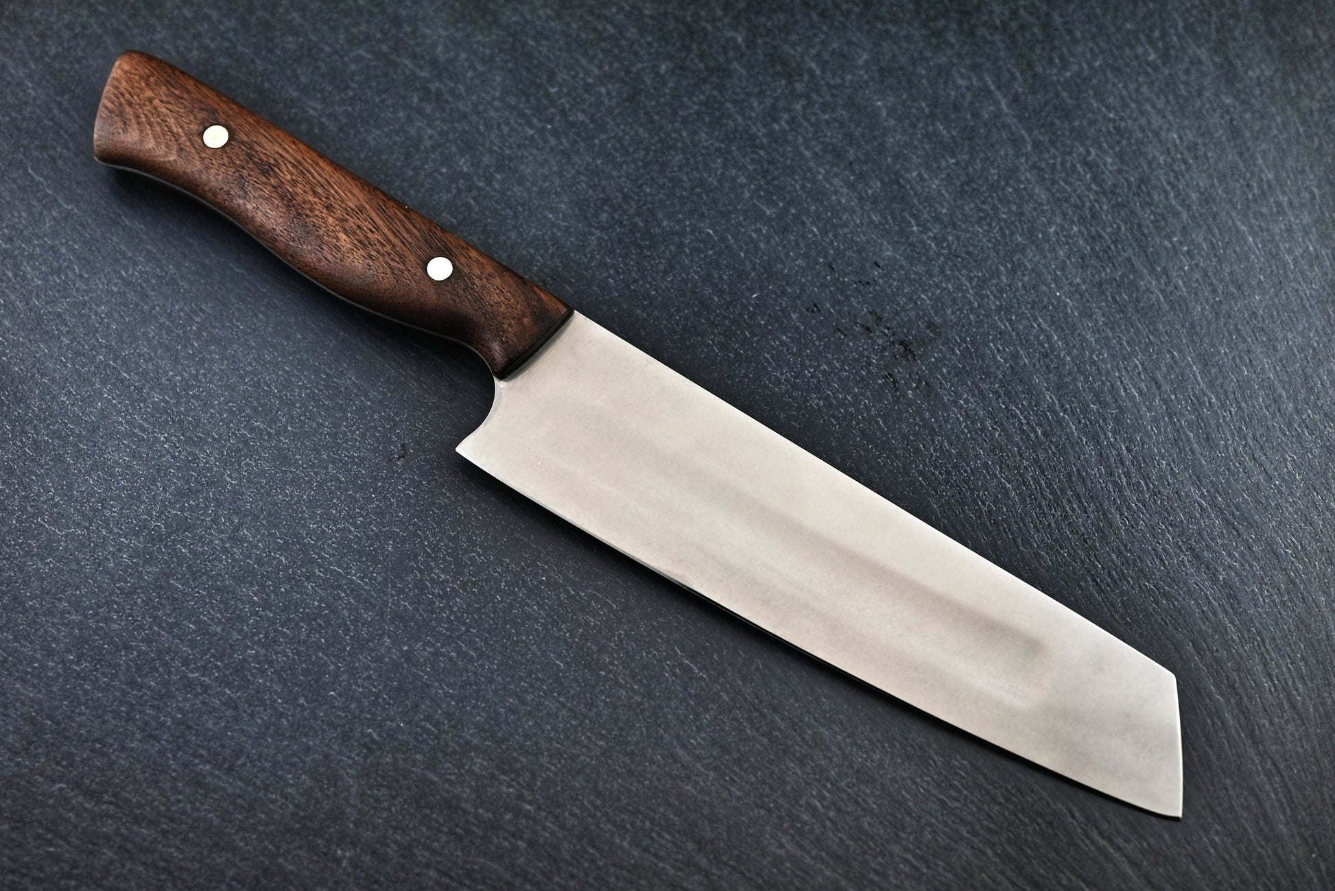 Santoku-Kochmesser seitlich: rostfreie Klinge und dunkler Holzgriff mit zwei Nieten